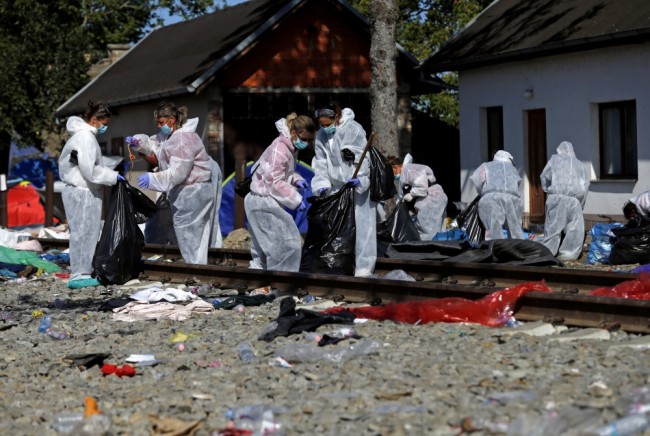 Хорватские волонтеры убирают мусор на железнодорожной станции в поселке Товарник после отправки беженцев. REUTERS/Scanpix