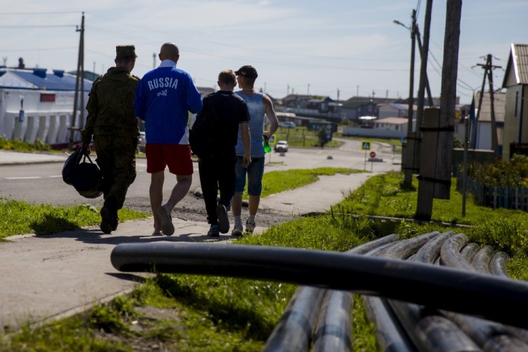 Men walk in the centre of Yuzhno-Kurilsk, the main settlement on the Southern Kurile Island of Kunashir September 14, 2015. Russian residents of the island chain at the centre of a dispute between Japan and Russia that has held up a treaty to formally end World War Two hope a diplomatic solution will lure tourists and investment to help refurbish rickety infrastructure. The Southern Kuriles are referred to in Japan as the Northern Territories. Picture taken September 14, 2015. REUTERS/Thomas Peter