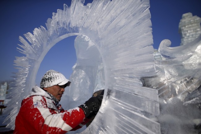 Рабочий полирует одну из скульптур накануне торжественной церемонии открытия Международного фестиваля снега и льда в Харбине. Фото REUTERS/Scanpix