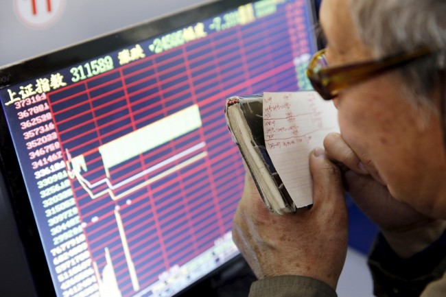 Инвестор сверяется со своими записями по котировкам. Фото Reuters/Scanpix