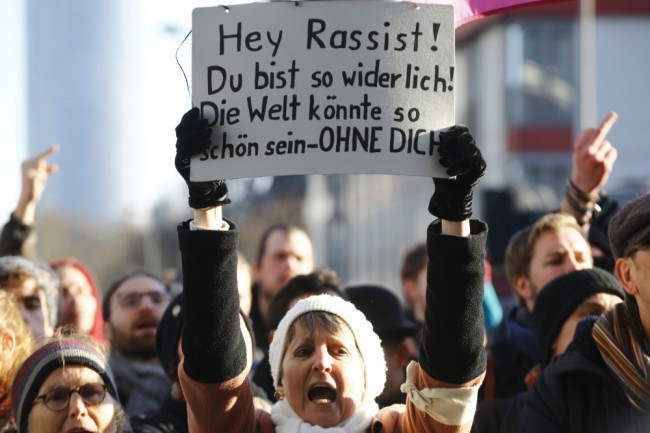 Противники анти-имиграционного движения PEDIGA. Надпись на плакате: Эй Расисты! Вы отвратительны! Мир может жить без вас! Фото   REUTERS/Scanpix