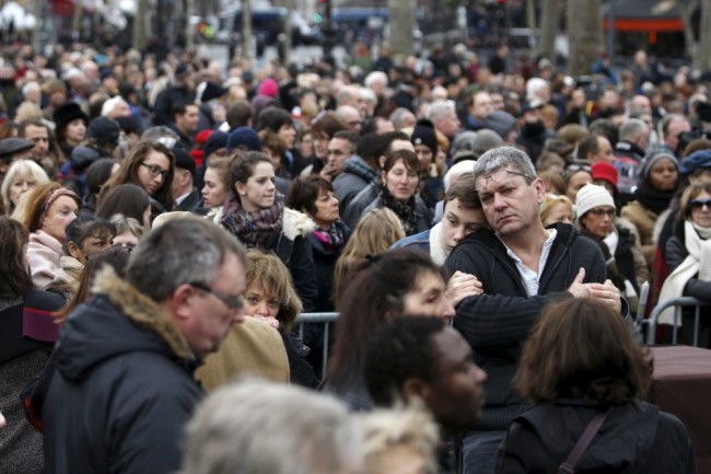 Люди пришедшие отдать дань памяти жертвам погибшим в января и ноябре 2015 года в Париже. Фото REUTERS/Scanpix