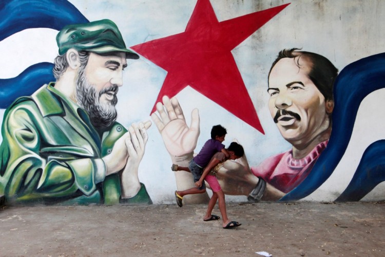 Children play in front of a mural of late former Cuban leader Fidel Castro and Nicaragua's President Daniel Ortega at the market in Managua, Nicaragua November 27,2016. REUTERS/Oswaldo Rivas  FOR EDITORIAL USE ONLY. NO RESALES. NO ARCHIVES