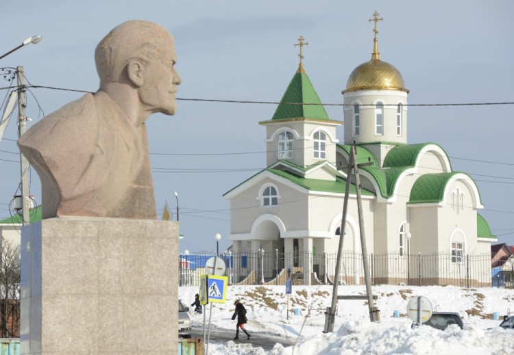 A bust of Soviet state founder Vladimir Lenin is seen in front of the Holy Trinity Cathedral in the settlement of Yuzhno-Kurilsk on the Island of Kunashir, one of four islands known as the Southern Kuriles in Russia and the Northern Territories in Japan, December 21, 2016. REUTERS/Yuri Maltsev