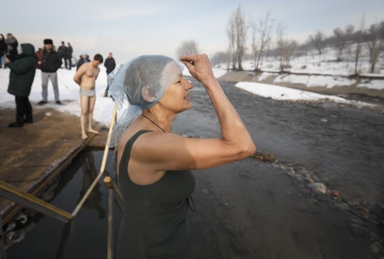 A woman crosses herself before taking a dip in icy waters of the Bolshaya Almatinka river during Orthodox Epiphany celebrations in Almaty, Kazakhstan January 19, 2017. REUTERS/Shamil Zhumatov