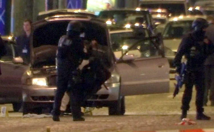 REFILE - CORRECTING CASUALTY NUMBER  A still image from video footage shows Police standing near the car used by the attacker on the Champs Elysees Avenue after a policeman was killed and two others were wounded in a shooting incident in Paris, France, April 20, 2017. REUTERS/Reuters Tv
