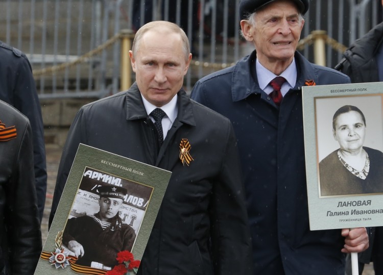 Russian President Vladimir Putin holds the portrait of his father, war veteran Vladimir Spiridonovich Putin, as he attends the Immortal Regiment march during the Victory Day celebrations, marking the 72nd anniversary of the victory over Nazi Germany in World War Two, in central Moscow, Russia, May 9, 2017. REUTERS/Sergei Karpukhin