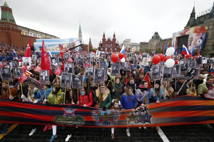 People carry flags and pictures of World War Two soldiers as they take part in the Immortal Regiment march during the Victory Day celebrations, marking the 72nd anniversary of the victory over Nazi Germany in World War Two, at Red Square in Moscow, Russia, May 9, 2017. REUTERS/Maxim Shemetov