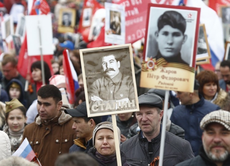 A woman holds a portrait of Soviet dictator Josef Stalin as she takes part in the Immortal Regiment march during the Victory Day celebrations, marking the 72nd anniversary of the victory over Nazi Germany in World War Two, at Red Square in Moscow, Russia, May 9, 2017. REUTERS/Maxim Shemetov