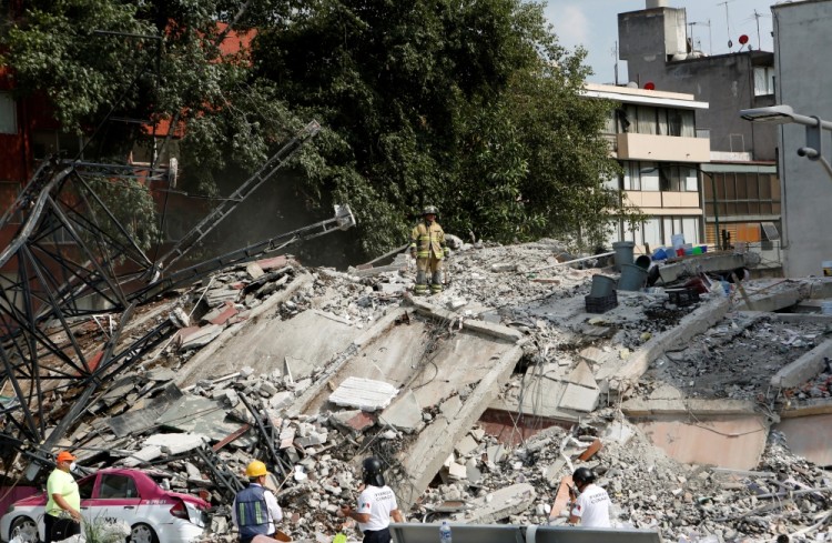 Rescuers work at a collapsed building after an earthquake in Mexico City, Mexico September 19, 2017. REUTERS/Ginnette Riquelme