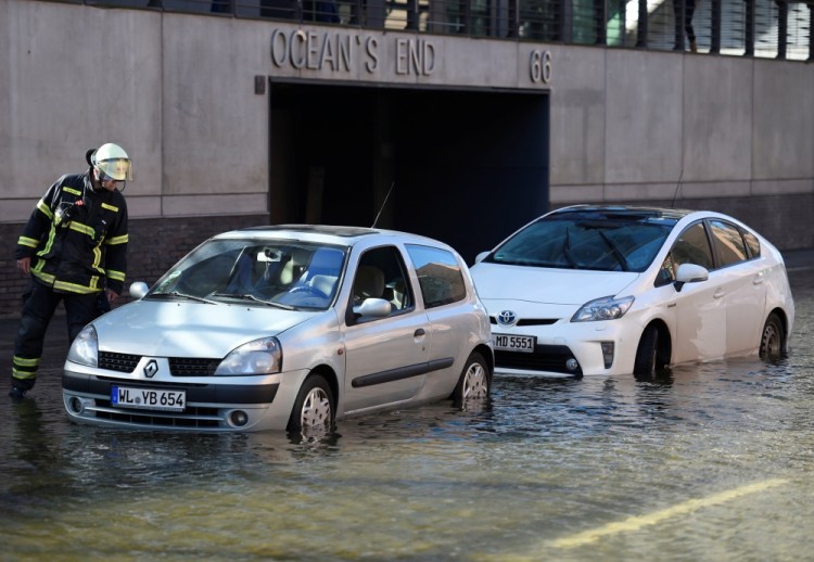 A firefighter checks cars in the HafenCity (Harbour City) district flooded during stormy weather caused by a storm called 