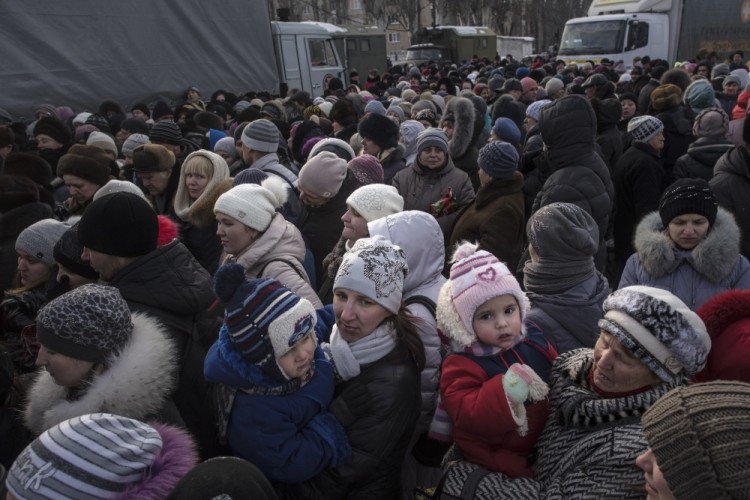 Local residents queue to receive food and humanitarian aid in Avdiivka, eastern Ukraine, Wednesday, Feb. 1, 2017. Freezing residents of an eastern Ukraine town battered by an upsurge in fighting between government troops and Russia-backed rebels flocked to a humanitarian aid center Wednesday to receive food and warm up. (AP Photo/Evgeniy Maloletka)