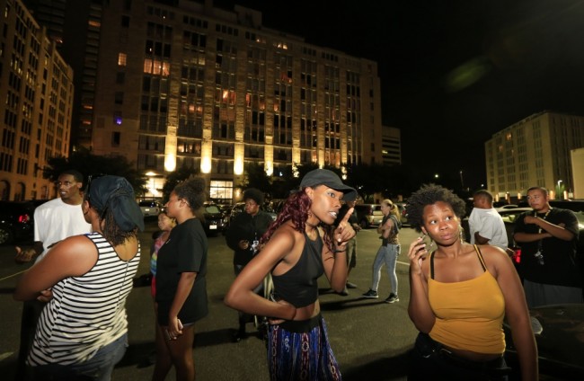 DALLAS, TX - JULY 7: Dallas residents stand near the scene where four Dallas police officers were shot and killed on July 7, 2016 in Dallas, Texas. According to reports, shots were fired during a protest being held in downtown Dallas in response to recent fatal shootings of two black men by police - Alton Sterling on July 5, 2016 in Baton Rouge, Louisiana and Philando Castile on July 6, 2016, in Falcon Heights, Minnesota.   Ron Jenkins/Getty Images/AFP == FOR NEWSPAPERS, INTERNET, TELCOS & TELEVISION USE ONLY ==