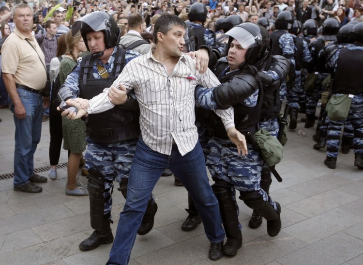 epa06024229 Russian police officers detain a participant of an unauthorized opposition rally in Tverskaya  street in central Moscow, Russia, on Russia Day, 12 June 2017. Russian liberal opposition leader and anti-corruption blogger Alexei Navalny has called his supporters to hold a protest in Tverskaya Street, which leads to the Kremlin, instead of the authorized by Moscow officials Sakharov avenue. Changing the location may provoke clashes with the police.  EPA/SERGEI CHIRIKOV