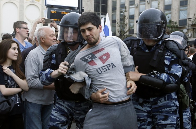 epa06024214 Russian police officers detain a participant of an unauthorized opposition rally in Tverskaya street in central Moscow, Russia, on Russia Day, 12 June 2017. Russian liberal opposition leader and anti-corruption blogger Alexei Navalny has called his supporters to hold a protest in Tverskaya Street, which leads to the Kremlin, instead of the authorized by Moscow officials Sakharov avenue. Changing the location may provoke clashes with the police.  EPA/SERGEI CHIRIKOV
