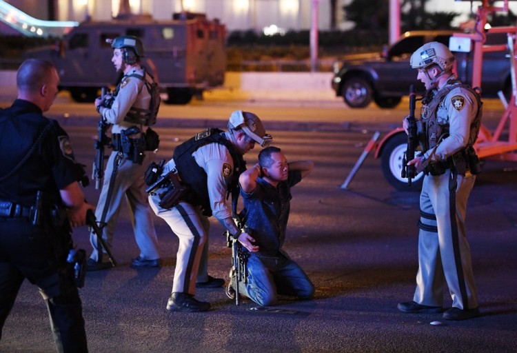 LAS VEGAS, NV - OCTOBER 02: Police officers stop a man who drove down Tropicana Ave. near Las Vegas Boulevard and Tropicana Ave, which had been closed after a mass shooting at a country music festival that left at least 2 people dead nearby on October 2, 2017 in Las Vegas, Nevada. The man was released.   Ethan Miller/Getty Images/AFP == FOR NEWSPAPERS, INTERNET, TELCOS & TELEVISION USE ONLY ==