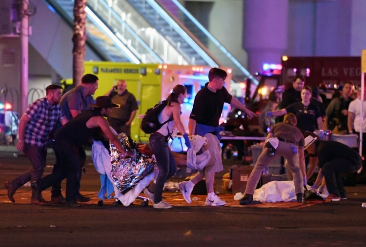 TOPSHOT - LAS VEGAS, NV - OCTOBER 02: An injured person is tended to in the intersection of Tropicana Ave. and Las Vegas Boulevard after a mass shooting at a country music festival nearby on October 2, 2017 in Las Vegas, Nevada. A gunman has opened fire on a music festival in Las Vegas, killing over 20 people. Police have confirmed that one suspect has been shot dead. The investigation is ongoing.   Ethan Miller/Getty Images/AFP / AFP PHOTO / GETTY IMAGES NORTH AMERICA / Ethan Miller