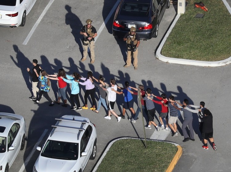 PARKLAND, FL - FEBRUARY 14: People are brought out of the Marjory Stoneman Douglas High School after a shooting at the school that reportedly killed and injured multiple people on February 14, 2018 in Parkland, Florida. Numerous law enforcement officials continue to investigate the scene.   Joe Raedle/Getty Images/AFP / AFP PHOTO / GETTY IMAGES NORTH AMERICA / JOE RAEDLE