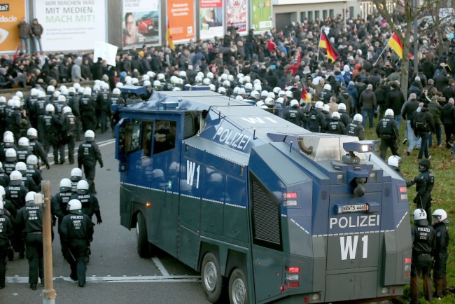 Полиция  начала использовать водометы после того как участники акции протеста стали бросать петардами и бутылками. Фото AFP/Scanpix