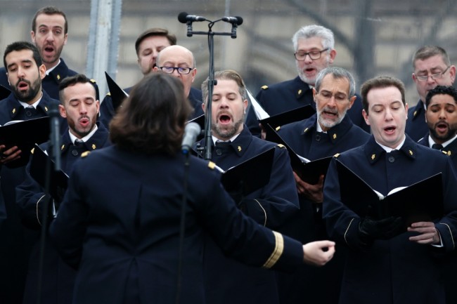 Members of French army choir sing during a remembrance rally at Place de la Republique (Republic square) on January 10, 2016 to mark a year since 1.6 million people thronged the French capital in a show of unity after attacks on the Charlie Hebdo newspaper and a Jewish supermarket. Just as it was last year, the vast Place de la Republique will be the focus of the gathering as people reiterate their support for freedom of expression and remember the other victims of what would become a year of jihadist outrages in France, culminating in the November 13 coordinated shootings and suicide bombings that killed 130 people and were claimed by the Islamic State (IS) group. / AFP / POOL / YOAN VALAT