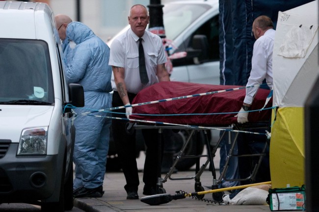 «Скорая помощь» увозит тело погибшей с места преступления. Фото: AFP / Scanpix