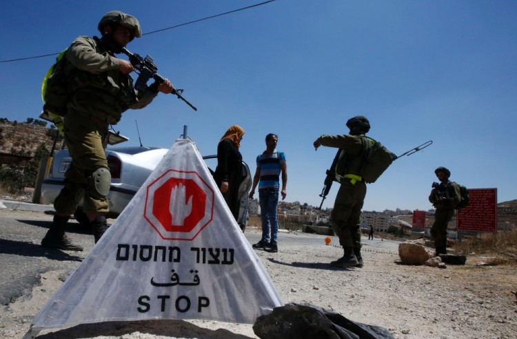 Досмотр палестинца израильскими военнослужащими на окраине Хеврона. Фото AFP/Scanpix