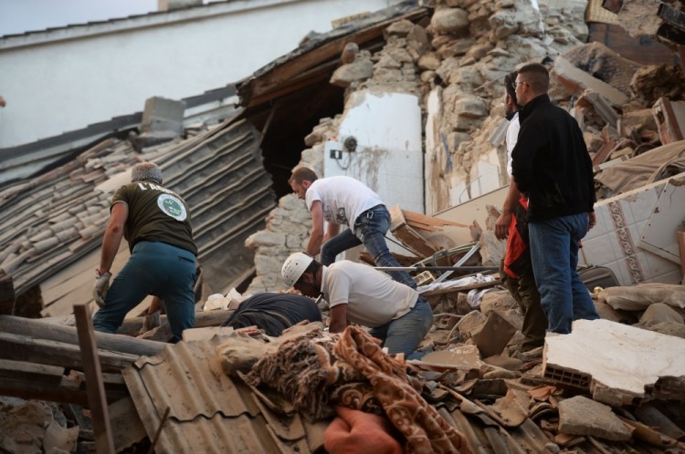 Спасатели и местные жители ищут возможных пострадавших в Аматриче. Фото: AFP / Scanpix