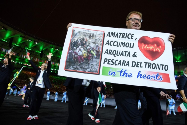 ...или итальянцев с плакатом в поддержку пострадавших в результате мощного землетрясения в центре страны. Фото: AFP / Scanpix