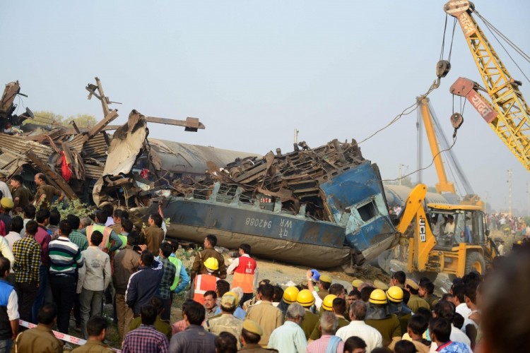 TOPSHOT - Indian rescue workers search for survivors in the wreckage of a train that derailed near Pukhrayan in Kanpur district on November 20, 2016. A passenger train derailed in northern India on November 20, killing at least 63 travellers most of whom were sleeping when the fatal accident occurred, police said. Rescue workers rushed to the scene near Kanpur in Uttar Pradesh state where the Patna-Indore express train derailed in the early hours of the morning. / AFP PHOTO / SANJAY KANOJIA