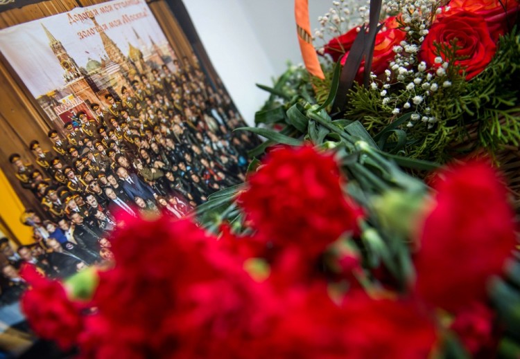 A picture and flowers are seen at the home stage building of the Alexandrov Ensemble (The Red Army Choir), in Moscow on December 25, 2016. The Russian military plane crashed on its way to Syria on December 25, with no sign of survivors among the 92 onboard, who included dozens of Red Army Choir members heading to celebrate the New Year with troops. Russia's defence ministry said a body had been recovered from the Black Sea. / AFP PHOTO / Alexander UTKIN