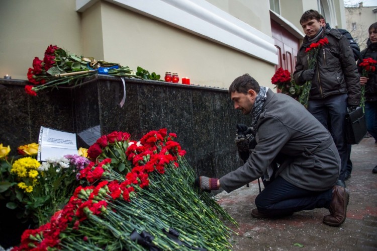 People lay flowers at the home stage building of the Alexandrov Ensemble (The Red Army Choir), in Moscow, on December 25, 2016, after a Russian military plane which included dozens of Red Army Choir members crashed.  The Russian military plane crashed on its way to Syria on December 25, with no sign of survivors among the 92 onboard, who included dozens of Red Army Choir members heading to celebrate the New Year with troops. Russia's defence ministry said a body had been recovered from the Black Sea. / AFP PHOTO / Alexander UTKIN