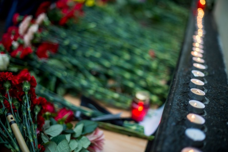 A picture shows candles and flowers layed at the home stage building of the Alexandrov Ensemble (The Red Army Choir), in Moscow, on December 25, 2016, after a Russian military plane which included dozens of Red Army Choir members crashed.  The Russian military plane crashed on its way to Syria on December 25, with no sign of survivors among the 92 onboard, who included dozens of Red Army Choir members heading to celebrate the New Year with troops. Russia's defence ministry said a body had been recovered from the Black Sea. / AFP PHOTO / Alexander UTKIN