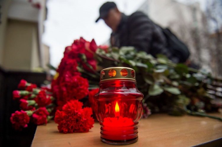 A man lays flowers at the home stage building of the Alexandrov Ensemble (The Red Army Choir), in Moscow, on December 25, 2016, after a Russian military plane which included dozens of Red Army Choir members crashed.  The Russian military plane crashed on its way to Syria on December 25, with no sign of survivors among the 92 onboard, who included dozens of Red Army Choir members heading to celebrate the New Year with troops. Russia's defence ministry said a body had been recovered from the Black Sea. / AFP PHOTO / Alexander UTKIN