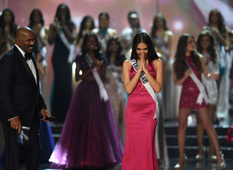 Miss Universe candidate Chalita Suansane of Thailand (R) acknowledges the audience next to pageant host Steve Harvey (L) during the finals of the Miss Universe pageant at the Mall of Asia Arena in Manila on January 30, 2017. Miss France was crowned Miss Universe on January 30 in a glitzy spectacle free of last year's dramatic mix-up but with a dash of political controversy as finalists touched on migration and other hot-button global issues. / AFP PHOTO / TED ALJIBE