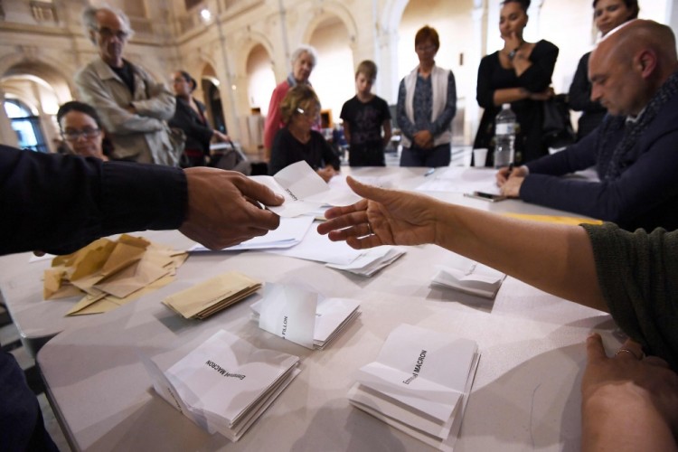Volunteers count the ballots at the end of the first round of the French presidential election first round vote in Marseille, southern France on April 23, 2017.   Centrist Emmanuel Macron will face off against far-right Marine Le Pen in the second round of France's presidential election, projections showed Sunday, making him clear favourite to emerge as the country's youngest leader in modern history. / AFP PHOTO / ANNE-CHRISTINE POUJOULAT