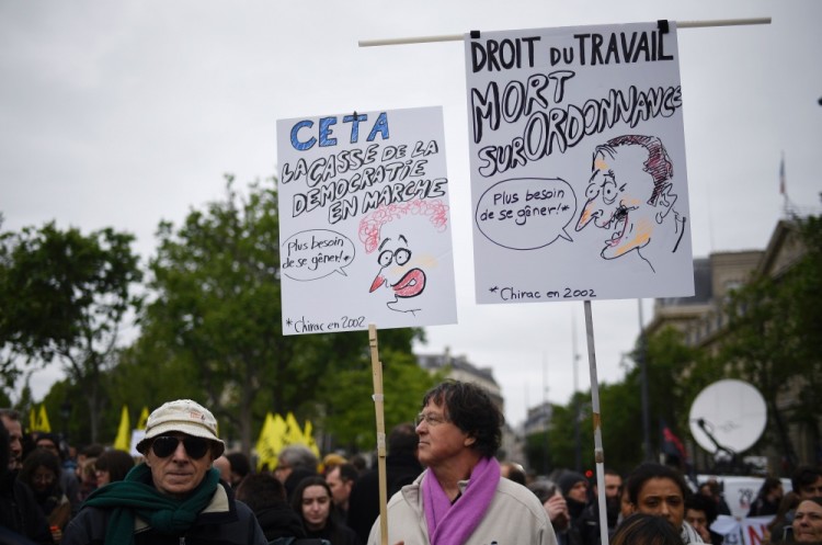 People hold placards as they take part in a demonstration called by the collectif 