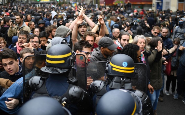 Riot police officers block a street while people take part in a demonstration called by the collectif 