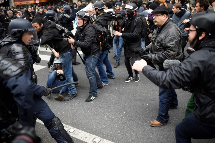 Riot police officers clash with people during a demonstration called by the collectif 