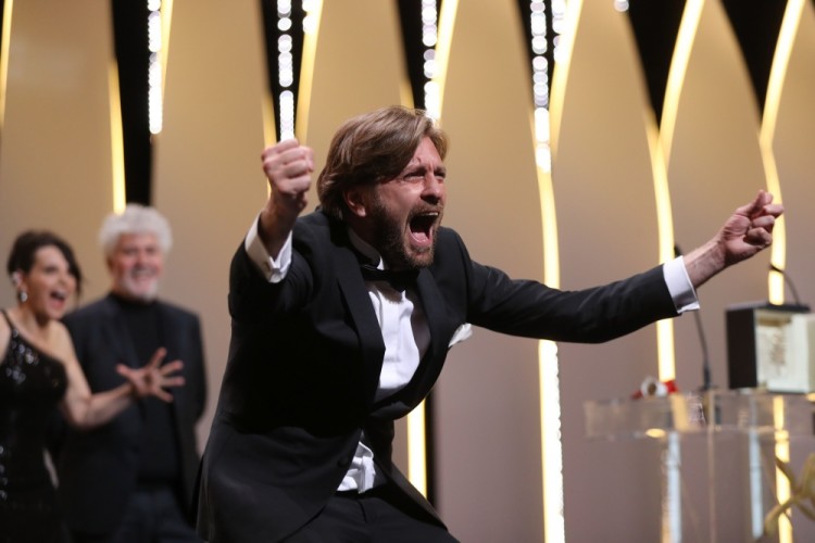 TOPSHOT - Swedish director Ruben Ostlund asks the audience to roar after he was awarded with the Palme d'Or for the film 'The Square' on May 28, 2017 during the closing ceremony of the 70th edition of the Cannes Film Festival in Cannes, southern France.  / AFP PHOTO / Valery HACHE