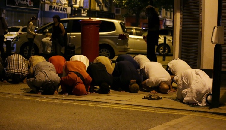 Muslims pray on a sidewalk in the Finsbury Park area of north London after a vehichle hit pedestrians, on June 19, 2017.  One person has been arrested after a vehicle hit pedestrians in north London, injuring several people, police said Monday, as Muslim leaders said worshippers were mown down after leaving a mosque. / AFP PHOTO / Daniel LEAL-OLIVAS