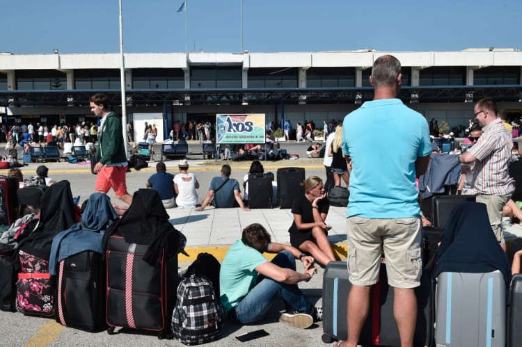 TOPSHOT - Tourists wait outside the terminal building at the airport on the Greek Island of Kos on July 21, 2017 following a 6.5 magnitude earthquake which struck the region.  Two foreigners died and more than 100 people were injured on the Greek island of Kos when an earthquake shook popular Greek and Turkish holiday destinations in the Aegean Sea. The epicentre of the 6.7 magnitude quake was some 10.3 kilometres (6.4 miles) south of the major Turkish resort of Bodrum, a magnet for holidaymakers in the summer, and 16.2 kilometres east of the island of Kos in Greece, the US Geological Survey said.  / AFP PHOTO / LOUISA GOULIAMAKI