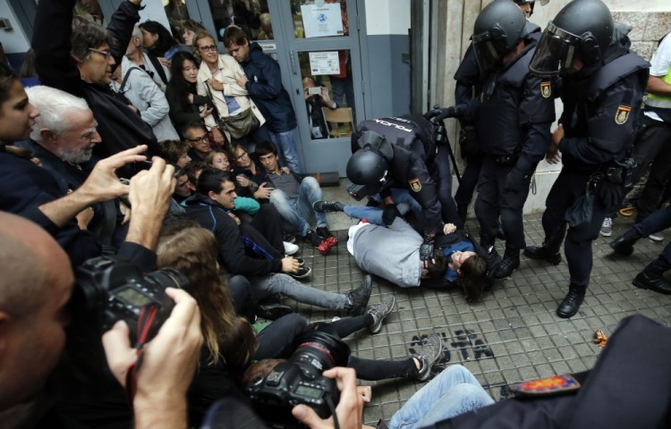 TOPSHOT - Spanish police officers immobilize some people outside a polling station in Barcelona, on October 1, 2017, on the day of a referendum on independence for Catalonia banned by Madrid. More than 5.3 million Catalans are called today to vote in a referendum on independence, surrounded by uncertainty over the intention of Spanish institutions to prevent this plebiscite banned by justice.  / AFP PHOTO / PAU BARRENA