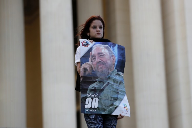 A student stands at attention holding images of Fidel Castro at the university where Castro studied law as a young man, during a vigil in Havana, Cuba, Sunday, Nov. 27, 2016. Castro, who led a rebel army to improbable victory in Cuba, embraced Soviet-style communism and defied the power of U.S. presidents during his half century rule, died Friday at age 90. (AP Photo/ Dario Lopez-Mills)