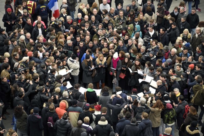 Members of the public sing following a remembrance rally at Place de la Republique (Republic square) on January 10, 2016 to mark a year since 1.6 million people thronged the French capital in a show of unity after attacks on the Charlie Hebdo newspaper and a Jewish supermarket. Just as it was last year, the vast Place de la Republique will be the focus of the gathering as people reiterate their support for freedom of expression and remember the other victims of what would become a year of jihadist outrages in France, culminating in the November 13 coordinated shootings and suicide bombings that killed 130 people and were claimed by the Islamic State (IS) group. AFP PHOTO / DOMINIQUE FAGET