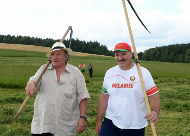 In this photo taken Wednesday, July 22, 2015, Belarus' President Alexander Lukashenko and French actor Gerard Depardieu, left, hold hand scythes as they walk in the presidential residence of Ozerny, outside Minsk, Belarus. Depardieu has frequented the former Soviet Union for years before he took Russian citizenship in 2013 in a bid to escape sky-high taxes in France. He has recently attracted the wrath of the Ukrainian government by condoning Russias annexation of Crimea.  (Andrei Stasevich/ BelTA Photo via AP)