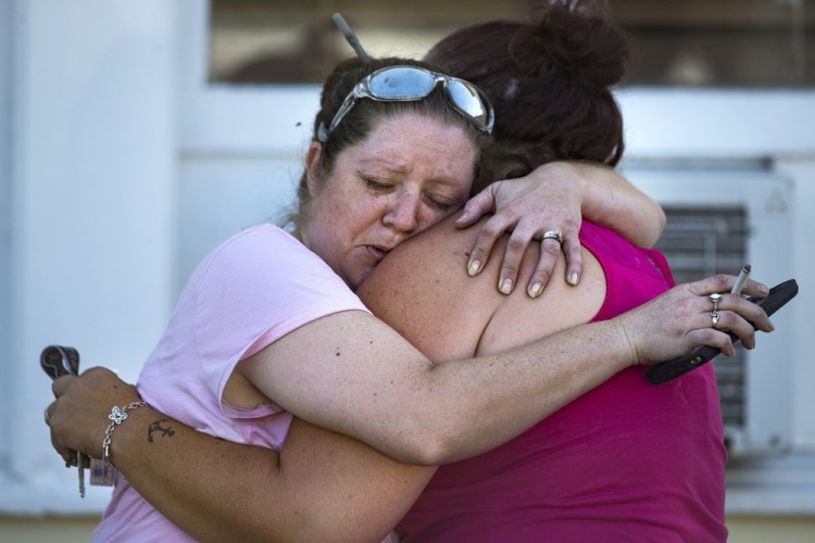 Carrie Matula embraces a woman after a fatal shooting at the First Baptist Church in Sutherland Springs, Texas, on Sunday, Nov. 5, 2017. Matula said she heard the shooting from the gas station where she works a block away. (Nick Wagner/Austin American-Statesman via AP)