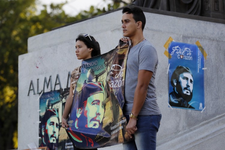 Students stand at attention holding images of Fidel Castro at the university where Castro studied law as a young man, during a vigil in Havana, Cuba, Sunday, Nov. 27, 2016. Castro, who led a rebel army to improbable victory in Cuba, embraced Soviet-style communism and defied the power of U.S. presidents during his half century rule, died at age 90. (AP Photo/ Dario Lopez-Mills)