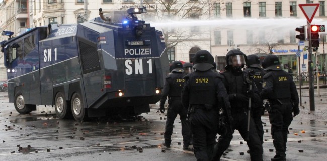Полиция Лейпцига использует водомета для разгона столкновения и тушеняи подоженных автомобилей и мусорных баков. 