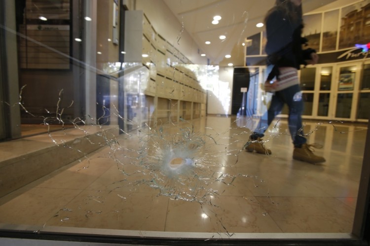 A damaged window is pictured on the Champs Elysees boulevard in Paris, early Friday, April 21, 2017. Paris' iconic Champs-Elysees boulevard is reopen and picking up its usual early morning routine Friday after a gunman opened fire on police, killing one officer and wounding three people before police shot and killed him.(AP Photo/Michel Euler)