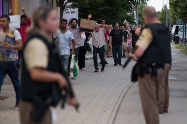 Полиция сопровождает покидающих торговый центр людей. Фото AP/Scanpix